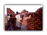 Christine helps build the wall of a new home in Malawi in 1998