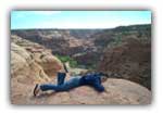 Neda grips the rocks to avoid being blown into the depths of Canyon de Chelly!
